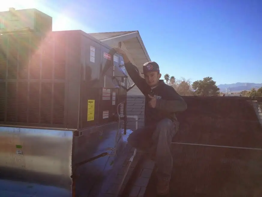 HVAC technician performing AC Tune-Up on a rooftop unit in Albert Lea